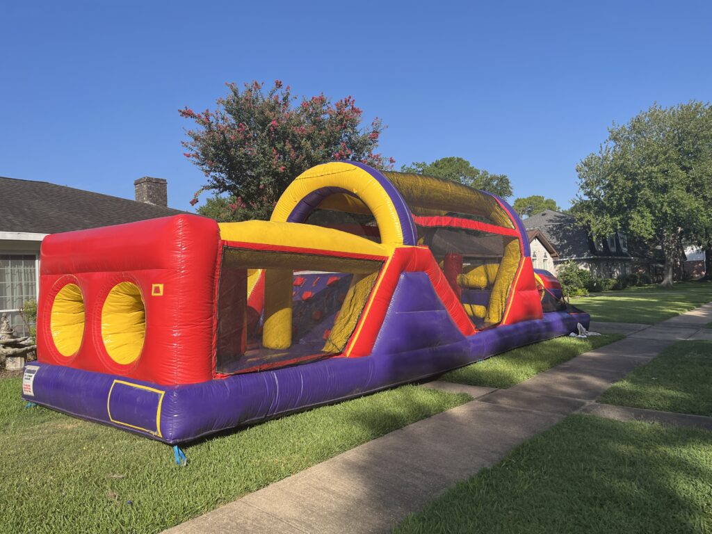 Children enjoying a colorful obstacle course at a backyard carnival in Sugar Land, Texas